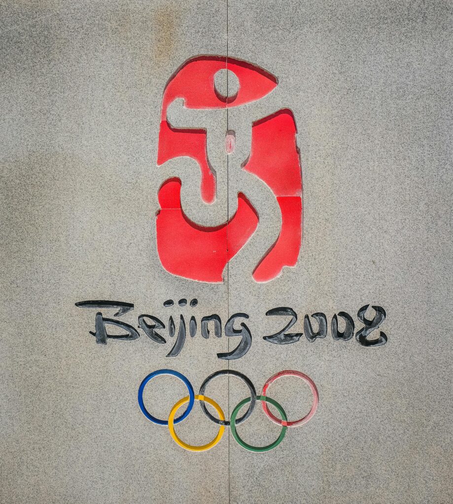 Close-up of the Beijing 2008 Olympic logo and rings on a concrete wall.